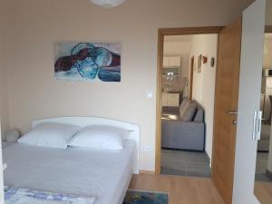 um quarto com uma cama e uma porta para uma sala de estar em Apartman Ante em Seget Vranjica
