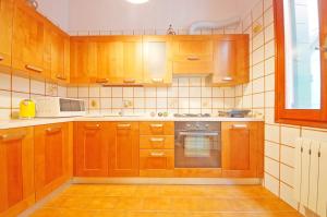 een keuken met houten kasten en een fornuis met oven bij DolceVita Apartments N 250 in Venetië