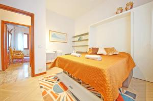 een slaapkamer met een bed met een oranje deken bij DolceVita Apartments N 250 in Venetië