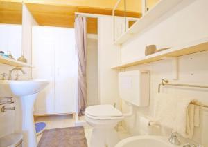 Baño blanco con aseo y lavamanos en DolceVita Apartments N 241 en Venecia