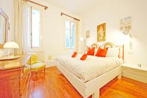1 dormitorio con cama blanca y almohadas de color naranja en DolceVita Apartments N 241, en Venecia