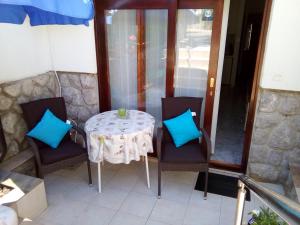 einen Tisch und Stühle mit blauen Kissen auf dem Balkon in der Unterkunft Apartments Vesna in Pinezici