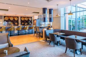 un ristorante con tavoli e sedie e un bar di Radisson Blu Hotel, Athlone a Athlone