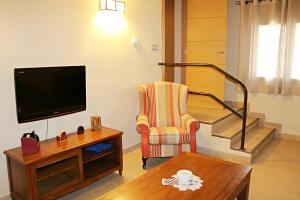 a living room with a tv and a chair and a table at Casa Santos in Albalate de Cinca