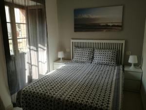 sypialnia z łóżkiem, 2 lampami i oknem w obiekcie APARTAMENTOS POBRA-CASTELO w mieście Pobra do Caramiñal