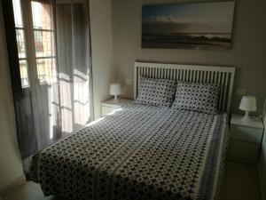 sypialnia z dużym łóżkiem i oknem w obiekcie APARTAMENTOS POBRA-CASTELO w mieście Pobra do Caramiñal