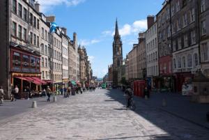 a city street with a clock tower in the distance at Parliament Square - Royal Mile in Edinburgh
