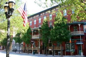 Um edifício de tijolos vermelhos com uma bandeira americana à frente. em The Inn at Jim Thorpe em Jim Thorpe