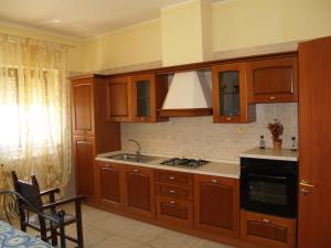 a kitchen with wooden cabinets and a stove top oven at Sogni d'Oro in Grottaglie