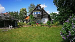 a black and white house with a yard at Agroturystyka Mazury Cicha Wólka in Zawady