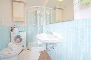 een badkamer met een wastafel en een wasmachine bij DolceVita Apartments N 329 in Venetië