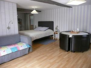 1 dormitorio con cama, sofá y mesa en B&B DINAN la priquetais en Trévron