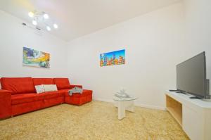 ヴェネツィアにあるDolceVita Apartments N 373のリビングルーム(赤いソファ、薄型テレビ付)