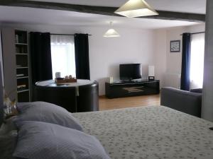 a bedroom with a bed and a desk and a tv at B&B DINAN la priquetais in Trévron