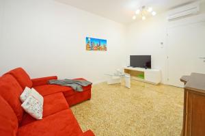 un soggiorno con divano rosso e TV di DolceVita Apartments N 374 a Venezia