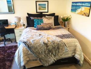 a bedroom with a bed and a desk with a computer at Sea view guest house in Auckland