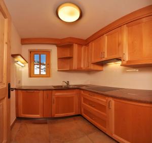 a kitchen with wooden cabinets and a sink at Agriturismo Maso Larciunei in Selva di Val Gardena