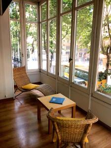 Zimmer mit einem Tisch, Stühlen und Fenstern in der Unterkunft Mayerling Schumann Barcelona in Barcelona