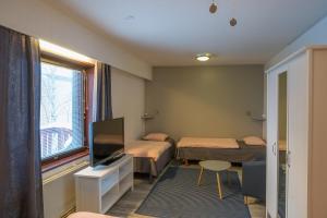 ロヴァニエミにあるゲストハウス ボレアリス アパートメンツのベッド2台、薄型テレビが備わる客室です。