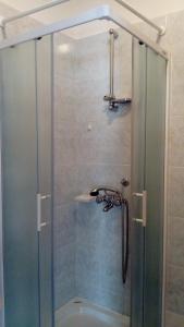 a shower with a glass door in a bathroom at Apartments Branko in Nin