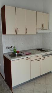 a kitchen with a sink and a stove and cabinets at Apartments Branko in Nin +48 photos