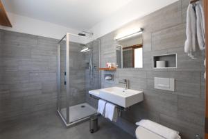 a bathroom with a sink and a shower at Hotel Stüa Granda in Soglio