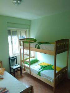 1 dormitorio con 2 literas y 1 silla en The Green Apartment, en Golem
