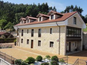 a large stone building with a basketball court in front at Hotel Mirador de Moriyón in Miravalles