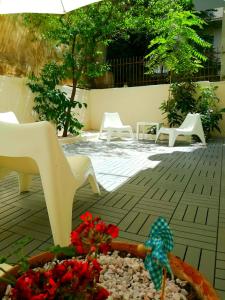 un jardín con sillas blancas y una mesa con flores en Charilaou Trikoupi Flat en Atenas