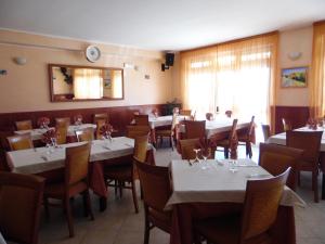 uma sala de jantar com mesas e cadeiras e uma mulher sentada no meio em Hotel Coste Del Lago em Limosano