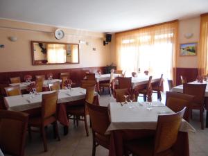 jadalnia ze stołami i krzesłami oraz kobieta siedząca w środku w obiekcie Hotel Coste Del Lago w mieście Limosano