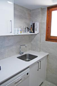 a white kitchen with a sink and a window at Albatros House in L'Escala +36 photos