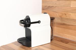 a black and white coffee maker on a wooden floor at City Home- Business Apartment in Nürnberg