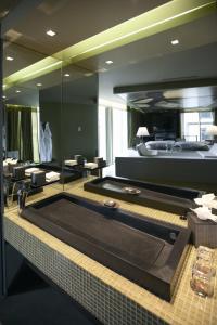 a large bathroom with a pool table and a tub at The Vine Hotel in Funchal