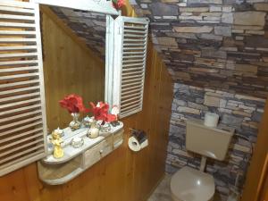 a bathroom with a stone wall and a toilet at Steinwandhütte in Stummerberg