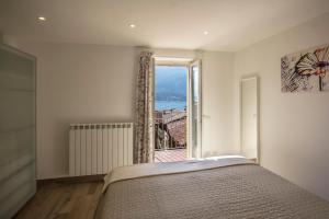 ein Schlafzimmer mit einem Bett und einem großen Fenster in der Unterkunft Appartamenti Meraviglia in Bellagio