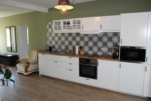 a kitchen with white cabinets and a stove at Ferienhaus Lilli in Pruchten