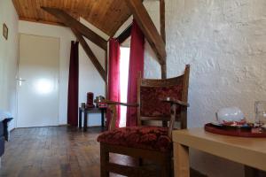 a room with a chair and a table and a window at Domaine Les Teuillères in Lacam-dʼOurcet