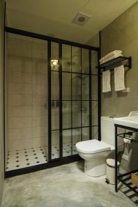 e bagno con servizi igienici, doccia e lavandino. di GOIN Old House & Bar a Tainan Altre 37 foto