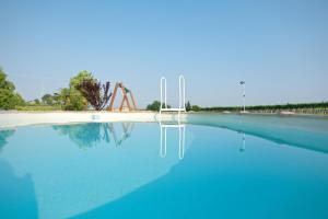 a large pool of blue water with a crane in the background at Agriturismo Albarello in Sona