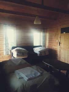 a room with three beds in a log cabin at Ostoja in Białowieża