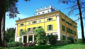 a large yellow building with benches in front of it at La Villa Palladienne - Château de Syam in Syam