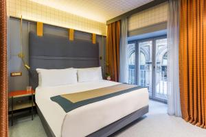 A bed or beds in a room at Room Mate Collection Giulia, Milan