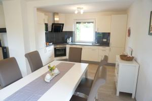 a kitchen with a white table and chairs in a room at Ferienhaus Tüxen in Hasselberg