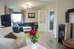 a living room with a couch and a vase of flowers at Ferienhaus Tüxen in Hasselberg