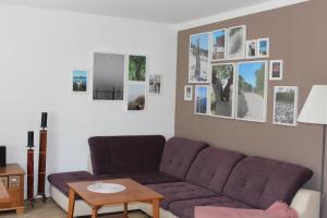 a living room with a purple couch and pictures on the wall at Ferienhaus Lilli in Pruchten
