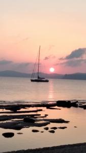 a sail boat in the water at sunset at Hotel Petras Beach in Sitia