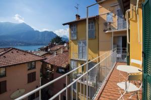 a balcony with a table and chairs on a building at Appartamenti Meraviglia in Bellagio