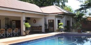 a house with a swimming pool in front of a house at 93 on Celliers Guesthouse in Louis Trichardt