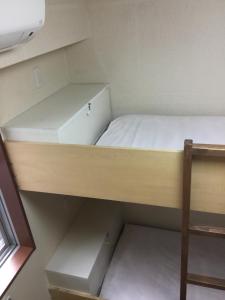 Mały pokój z łóżkiem piętrowym i półką w obiekcie Yamate Rest House (Male Only) w Tokio